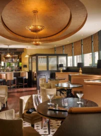Warm hotel lounge with family-friendly seating, a bartender preparing drinks at the bar