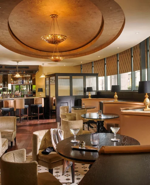 Warm hotel lounge with family-friendly seating, a bartender preparing drinks at the bar