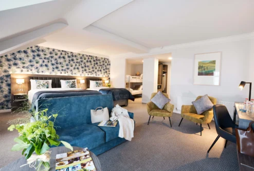 Spacious family suite with two double beds, bunk beds, sofas and cosy seating in warm décor