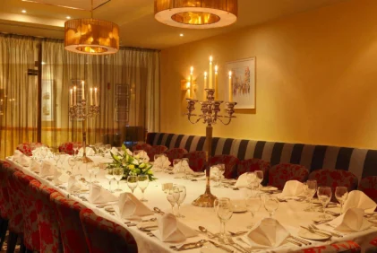 Elegant family dining table set for a celebratory meal in a warm hotel private dining room