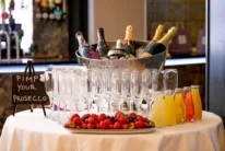 Family enjoying a prosecco station with glasses, fruit platter and mixers at a hotel reception