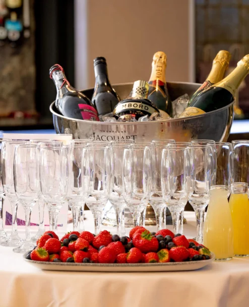 Family enjoying a prosecco station with glasses, fruit platter and mixers at a hotel reception